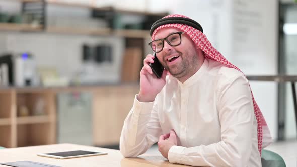 Young Arab Businessman Talking on Smartphone in Office