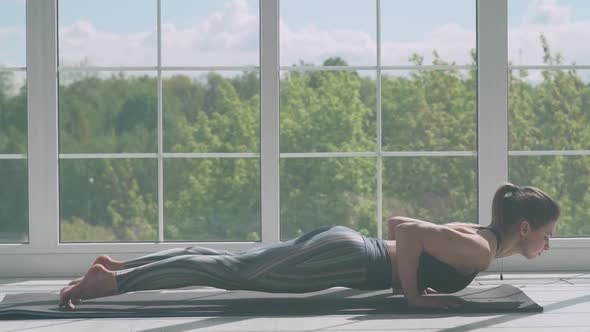 Young Woman is Doing Yoga in a White Room Filled with Light the Girl Performs Yoga Stands and