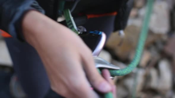 A young man preparing carabiners to go rock climbing.