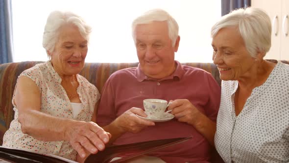 Happy senior friends looking at a photo album