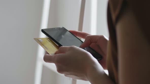 Asian caucasian woman using smartphone shopping online and use the credit card payment.