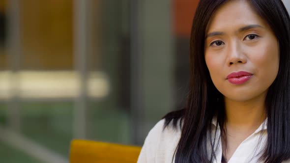 Portrait of Smiling Asian Woman Touching Her Hair