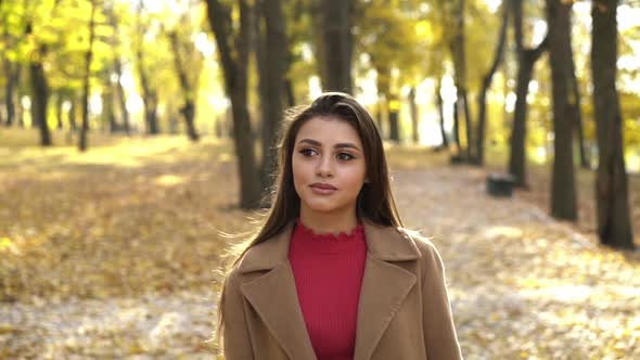 Seductive Girl Walks in the Sunny Autumn Park Poses and Admires the Nature