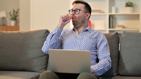 Sick Young Man Using Laptop Coughing at Home