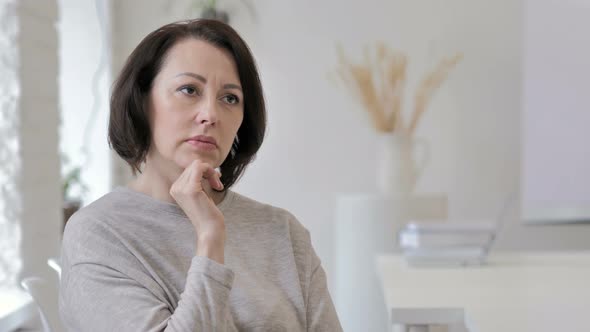 Portrait of Thinking Old Senior Woman in Office