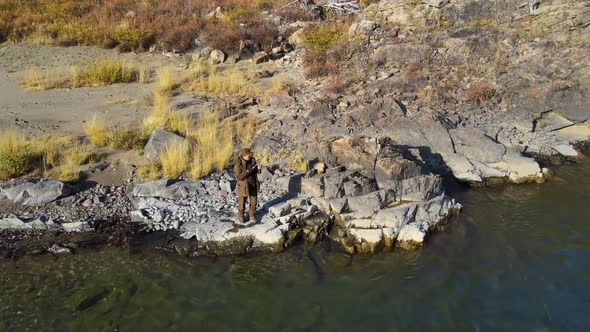 River Autumn Fisherman Fishing at the Edge of a Cliff Fishing Rod From a Copter