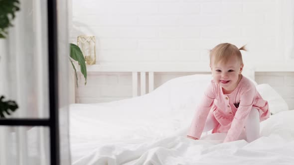 Happy Child Girl Having Fun Jumping and Playing Funny Active Game in Parents Bed Bouncing Fooling