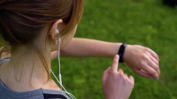Girl in Nature Uses a Smart Watch