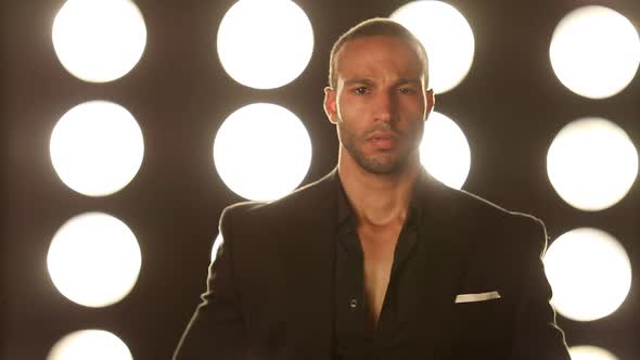 Handsome and stylish man in front of a wall of lights