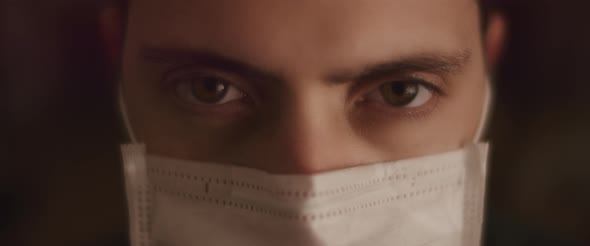 Extreme Close up Of a Young Man Opening His Eyes While Wearing a Protective Mask