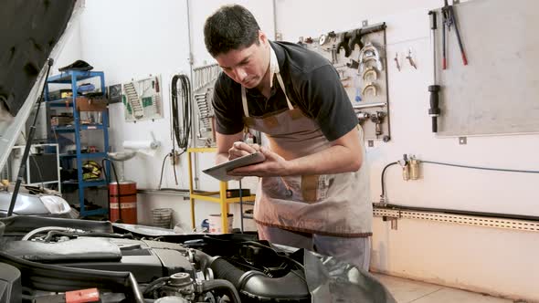 Mechanic checking car, taking notes and opening windshield washer bottle cap