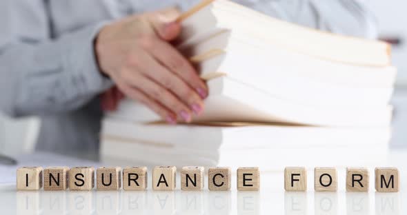 Woman Sorting Documents on Background of Wooden Cubes with Word Insurance Forms  Movie Slow Motion