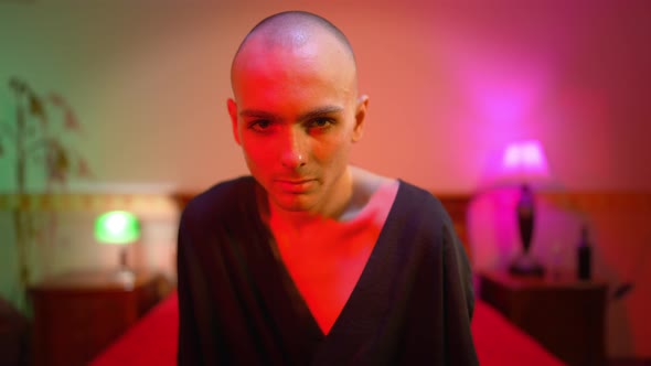 Portrait of Young Male Queer Posing in Red Light Indoors