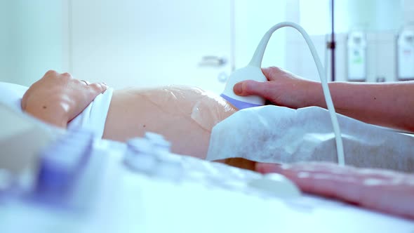 In the Hospital, Close-up Shot of the Doctor Does Ultrasound / Sonogram Procedure To a Pregnant