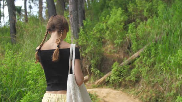 Slim Girl Walks Along Highland Path Surrounded By Trees