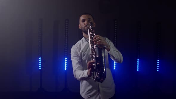 Live Performance of Saxophonist Man with Saxophone Dancing on Concert Musician Stage with Lights
