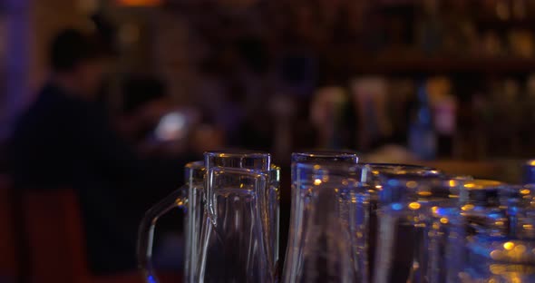 Glassware and man with pad in cafe