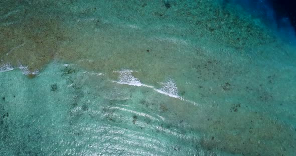 Wide flying abstract shot of a white sandy paradise beach and blue water background in best quality 