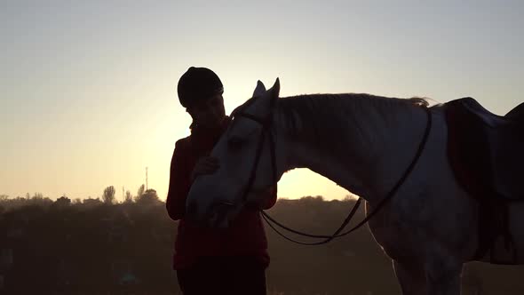 Horsewoman Kisses a Horse at Sunsetcc