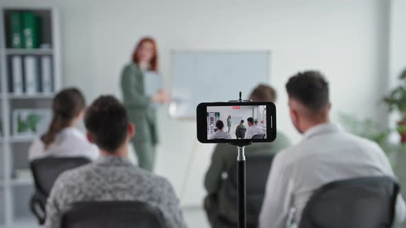 Online Training a Young Female Entrepreneur Makes a Presentation to a Working Team Showing a Graph