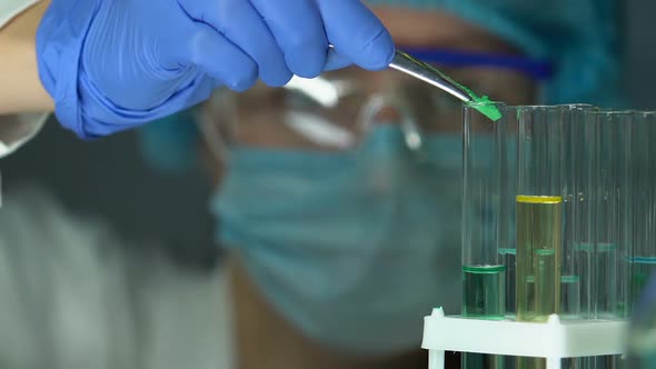 Researcher in Safety Glasses Adding Reagent Into Test Tube, Observing Reaction