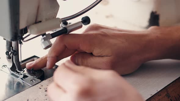 The Master Is Preparing a Sewing Machine for Work