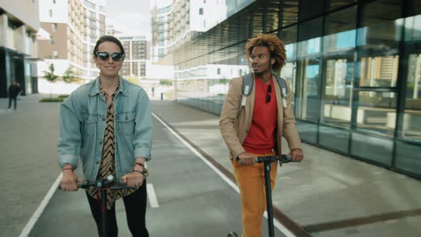 Multiethnic Friends Riding E-Scooters in City