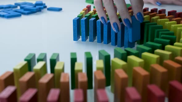 Line up of Dominoes in Rainbow Falling Colors with LGBT Colors of a Hand