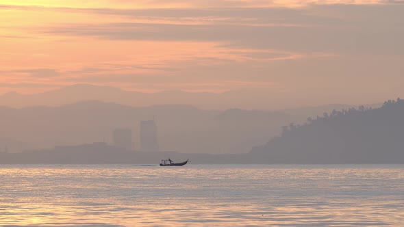 Fishing boat move at sea in golden morning