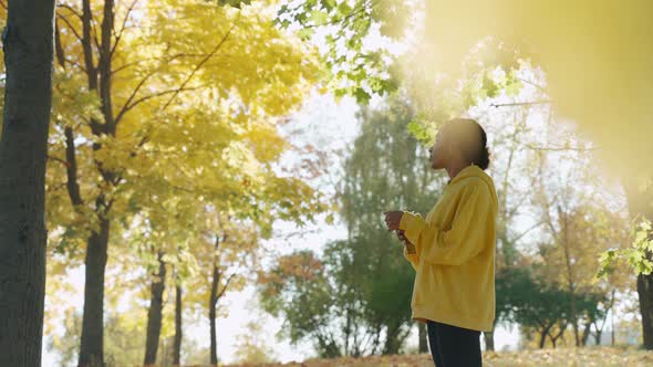 Young Girl Drinking Water Before Run at the Park in Sunny Autumn Morning