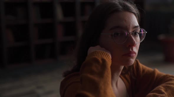 Tracking Shot of Pensive Young Woman in Glasses Playing Chess Indoor and Thinking Position Find