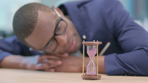 African Businessman Waiting Looking at Hourglass