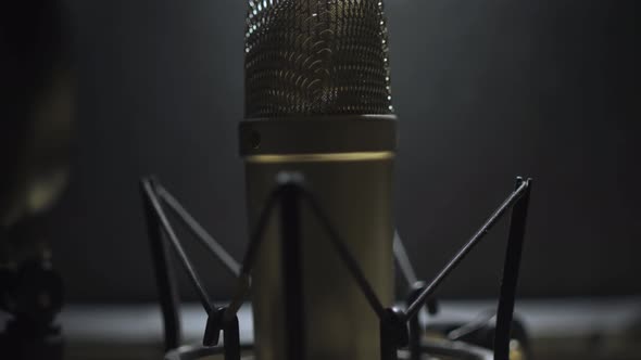 Tilt up on Voice Over microphone in a dark studio recording room