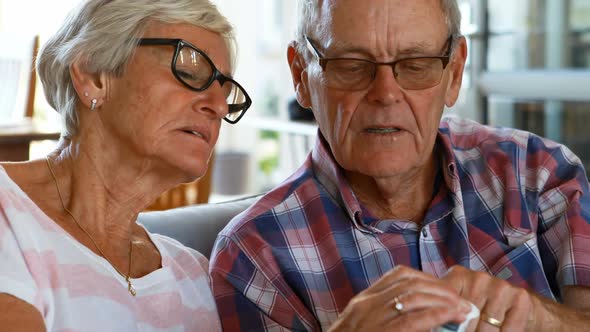 Senior couple discussing medication on sofa 4k
