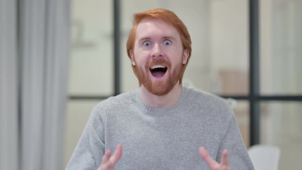 Portrait of Excited Young Redhead Man Celebrating