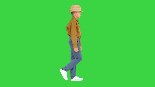 Boy in a Shirt Adjusting His Straw Hat While Walking and Looking at Camera on a Green Screen, Chroma