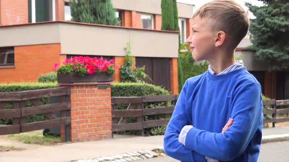 A Young Boy Looks Around in a Suburban Street