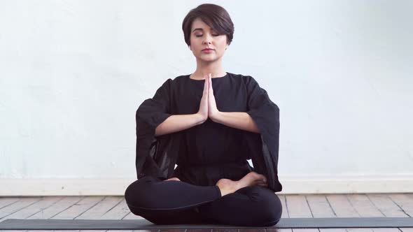 Young and fit woman practicing yoga indoor in the class.