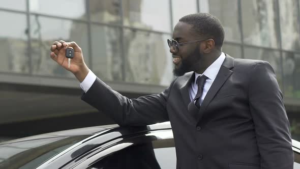 Successful Business Man Holding Key From New Car in in Hand and Smiling Happily