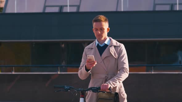Man with smartphone going near bicycle