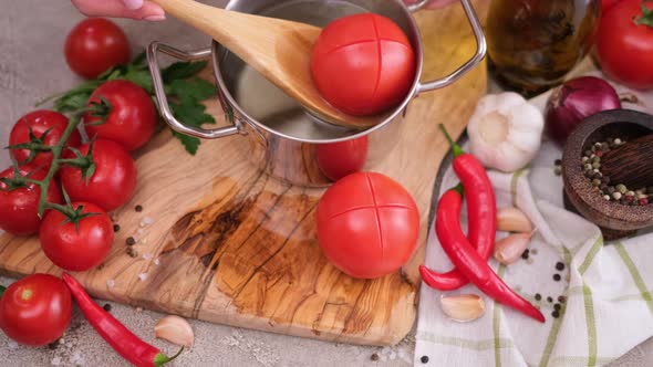 Woman Blanching Tomato in Pot with Hot Boiling Water