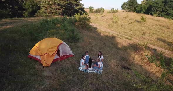 Girls Have Fun on a Picnic Near the Tent