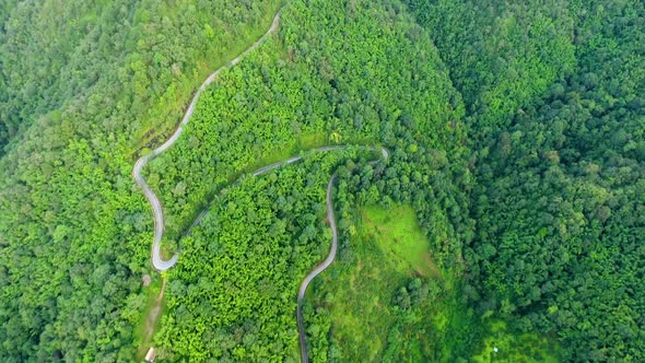 Aerial view of road on mountains and forest.