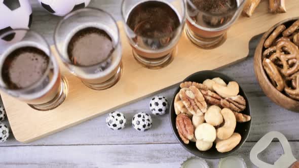 Draft beer and salty snacks on the table for soccer party.