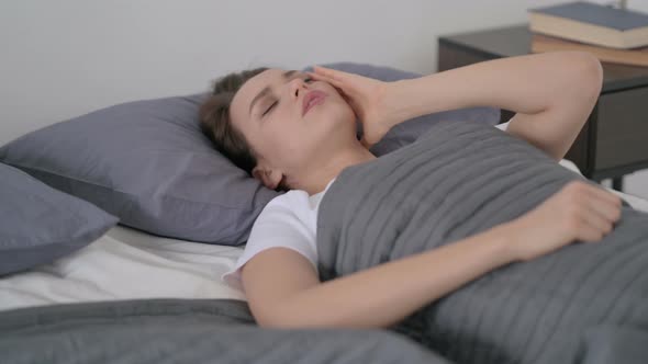 Woman Having Headache While Sleeping in Bed