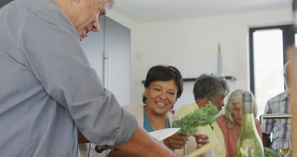 Happy senior diverse people cooking in kitchen at retirement home