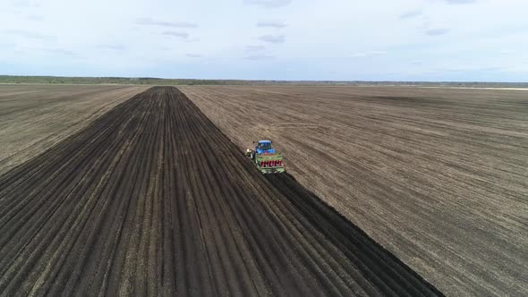 Aerial view of a blue tractor plant potatoes. 02