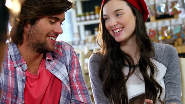 Smiling man and woman interacting over mobile phone