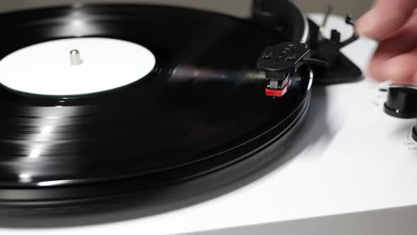 Hand turns on a vintage vinyl record. Vinyl turntable with vinyl plate. Gramophone record player. Re