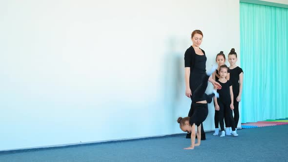 Young Lady in Tracksuit Practices Cartwheels in Dance Studio